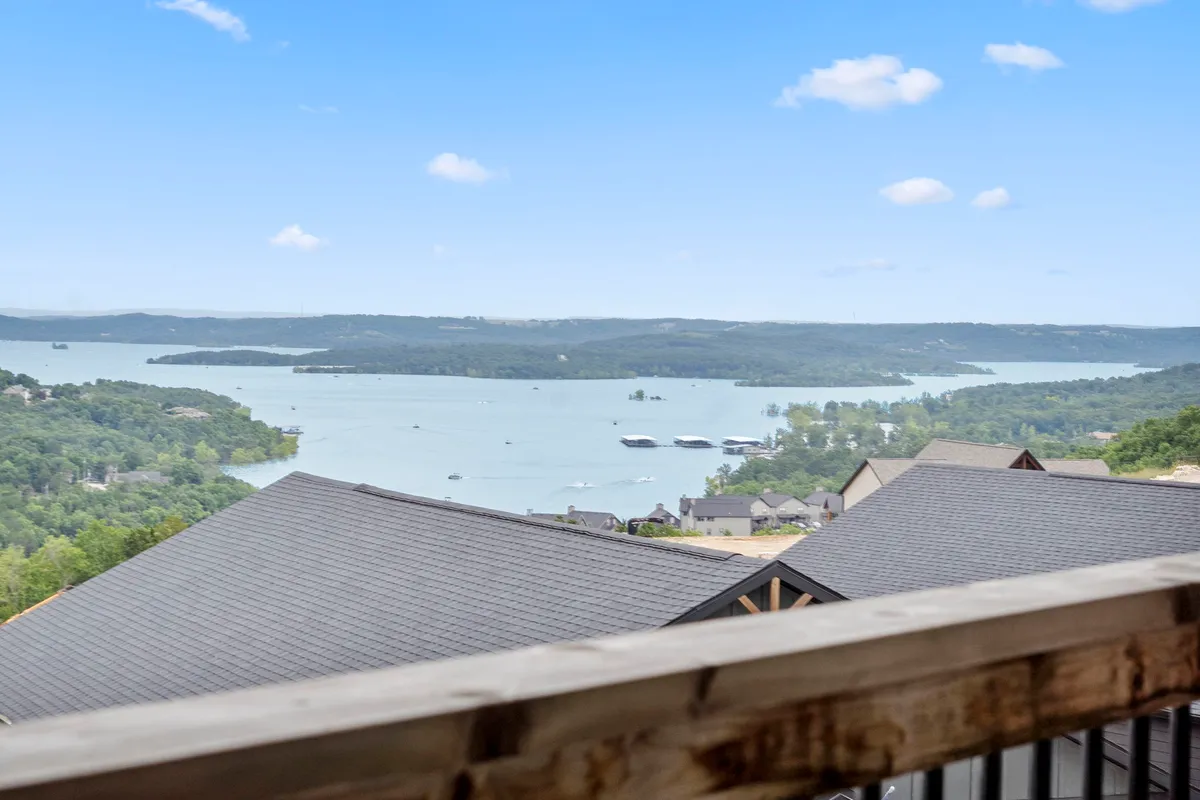 An expansive view of Table Rock Lake with distant green hills under a blue sky. The image is tranquil and inviting, emphasizing the natural beauty and serenity of the lake, which serves as a backdrop for many guest activities.
